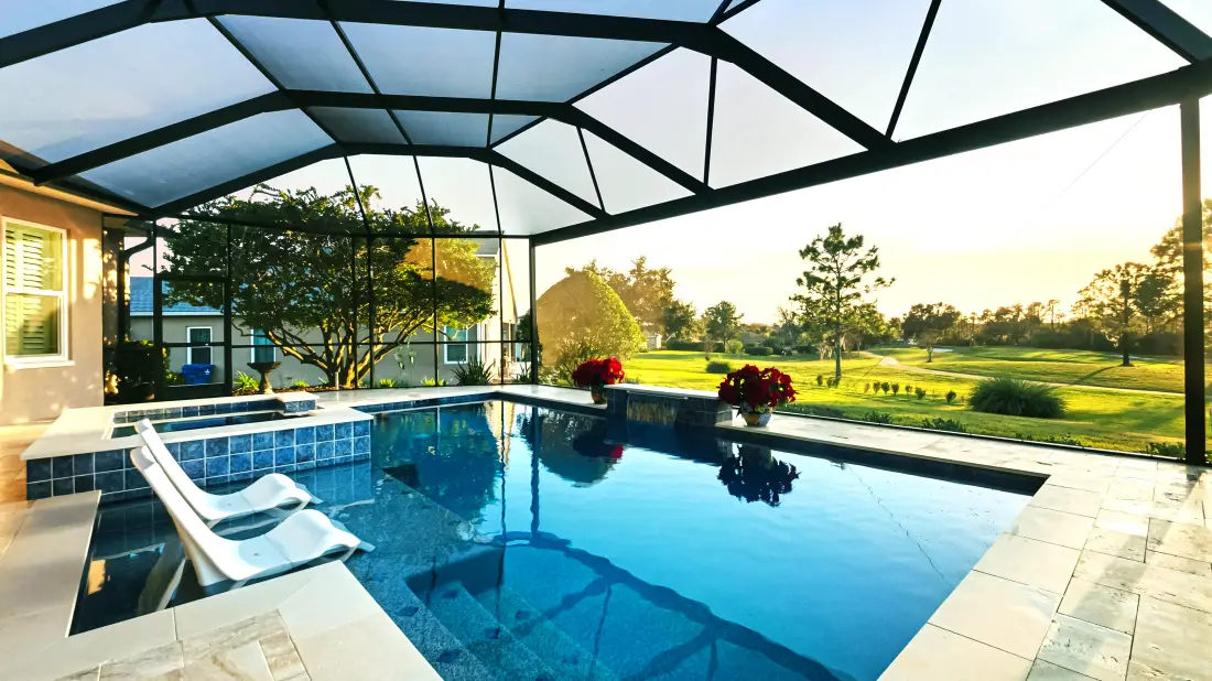 Screened lanai enclosure over the pool and lounge chairs, golf course view.