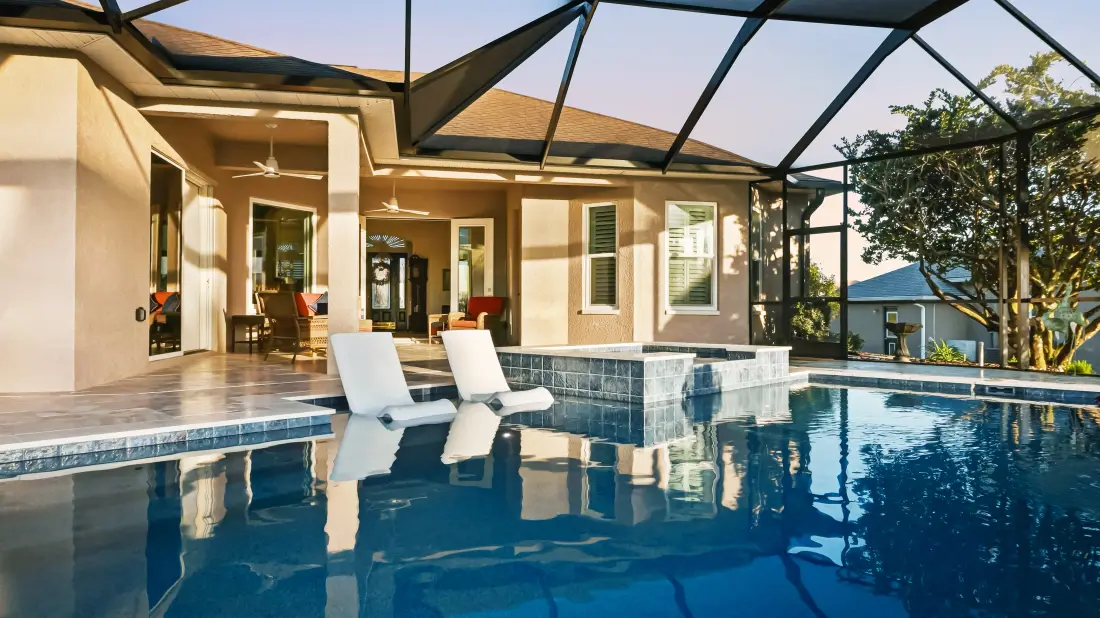 View through the screened lanai toward the pool and golf course in early light.