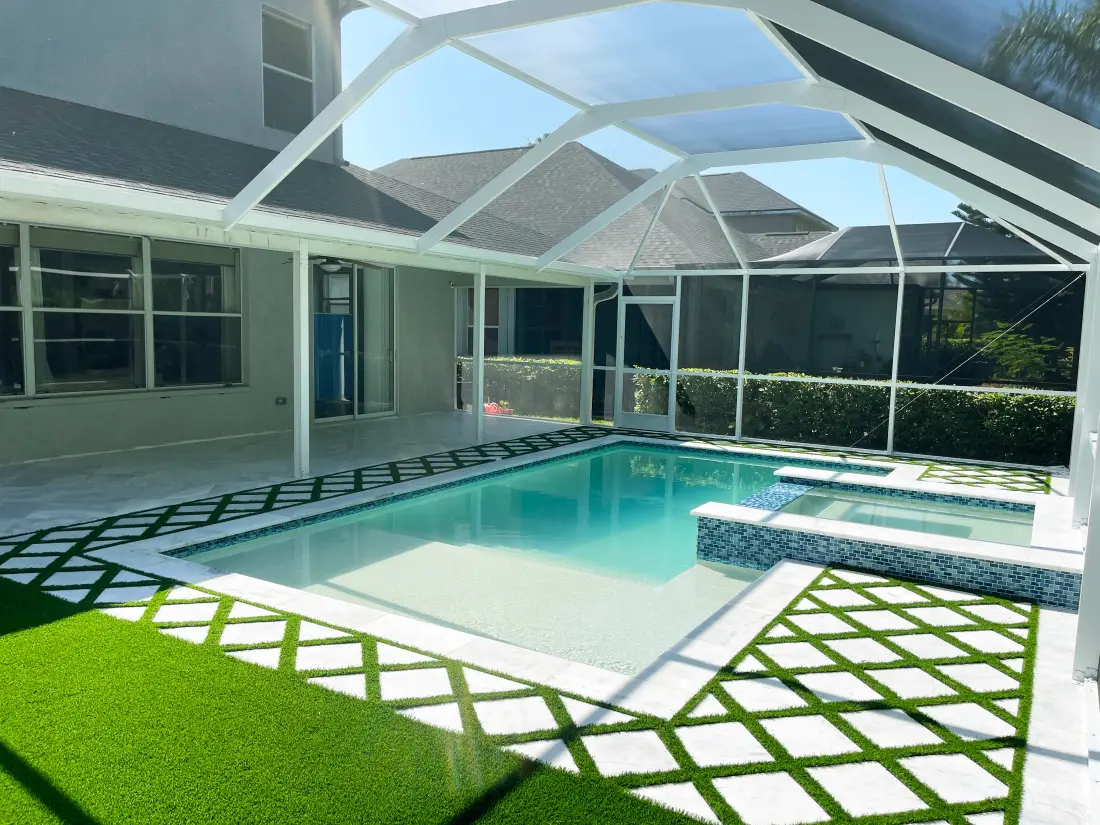 Screened lanai pool with a checkerboard concrete paver deck.