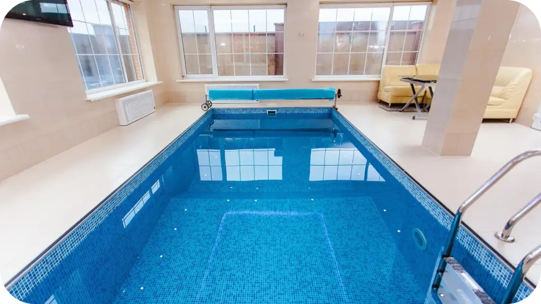 Indoor pool with a cover reel at one end.