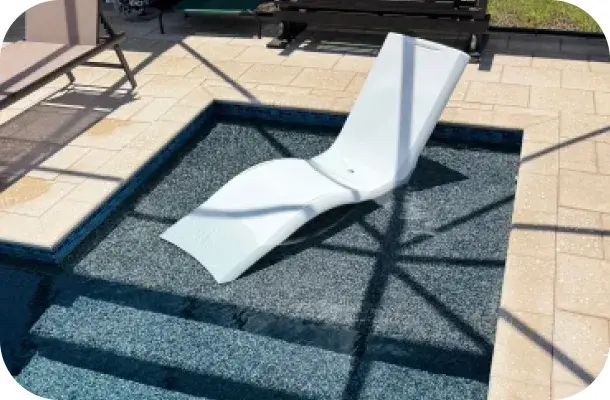 In-pool tanning ledge with a white lounge chair submerged at the shallow end.