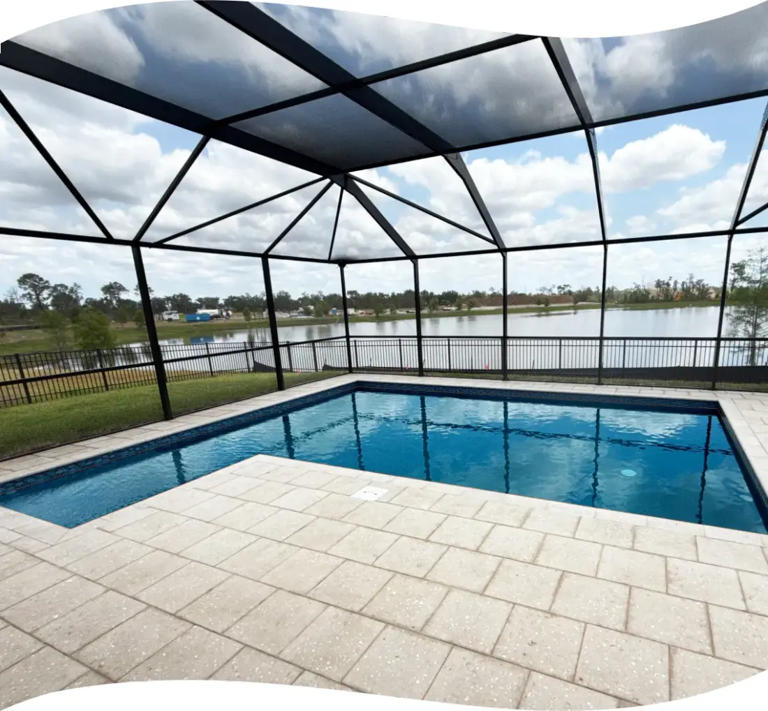 Wide angle of the screened pool enclosure with a pond and open sky beyond.