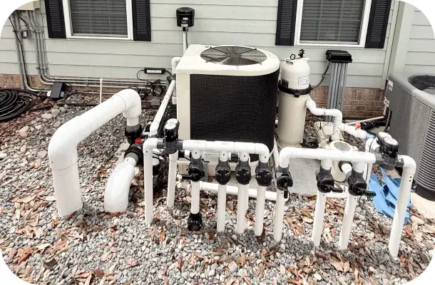 Pool equipment pad with pump, filter, and heater installed beside the house.