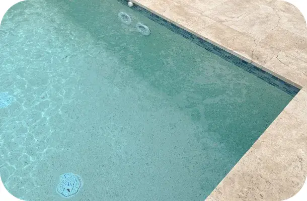 Close view of the pool's shallow-end steps and bench seating.
