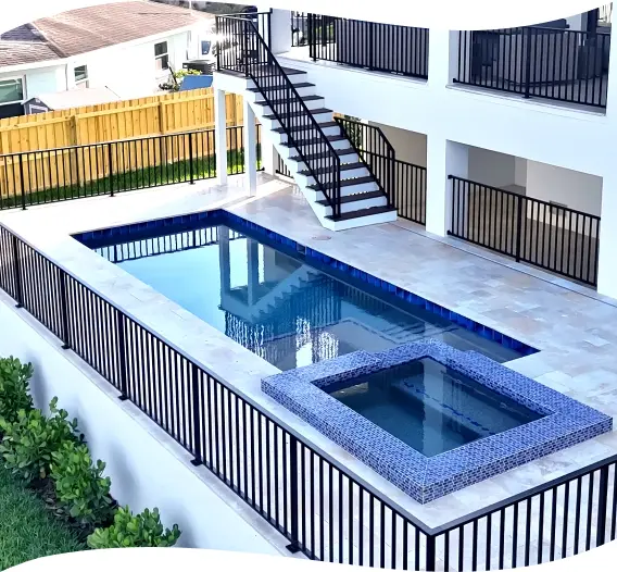 Elevated pool deck with black metal railings and a stairway down to the yard.