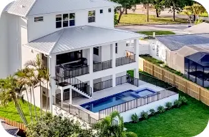 Elevated view of the raised pool structure, home exterior, and access stairs.