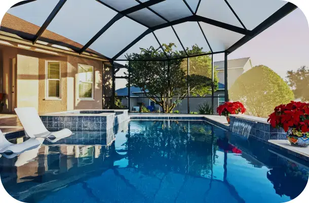Screened pool and spa with lounge chairs, golf course view in warm evening light.