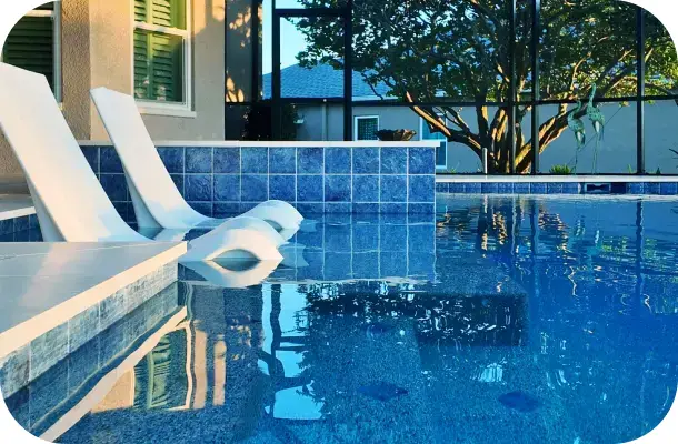 Close view of the pool and raised spa corner with loungers reflected in the water.