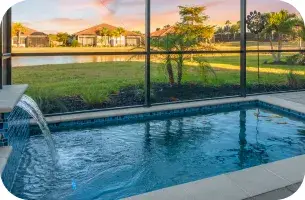 Screened lanai pool with a water-jet feature and a pond view beyond the screen.