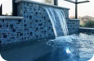 Close-up of water spilling over the raised spa's blue glass-tile wall.