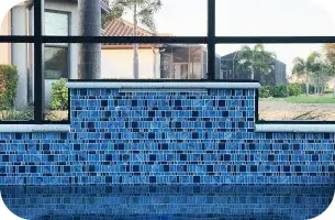Close view of the spa's blue glass-tile waterfall wall in evening light.