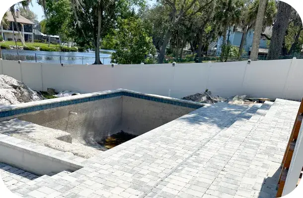 Pool shell mid-construction with poured concrete walls, decking not yet finished.