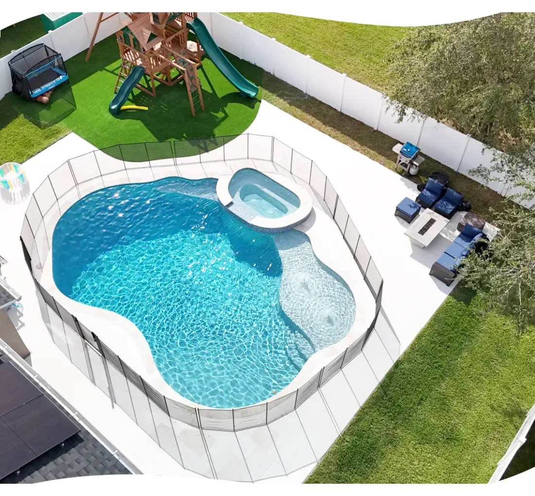 Elevated view of the freeform pool and round spa beside a play structure.