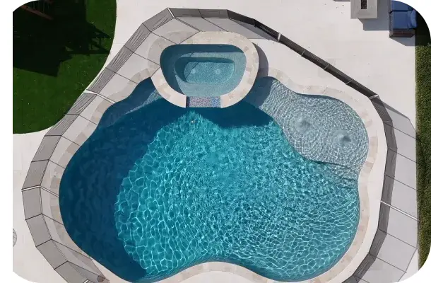 Aerial angle of the freeform pool and spa with the playset nearby.