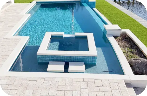 Pool and raised square spa with jets and built-in bench seating on paver decking.