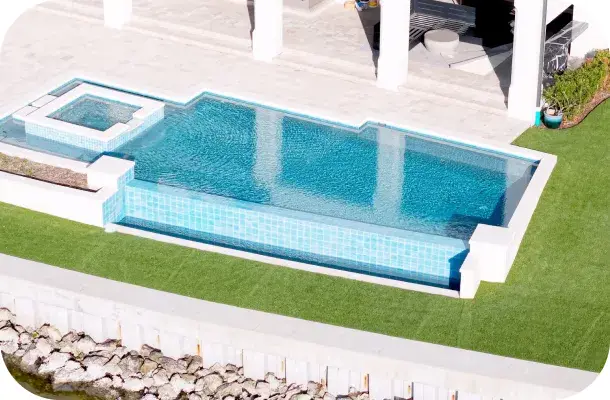 Elevated view of the pool and raised spa with patio furniture near the home.