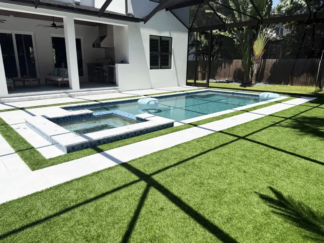 Elevated view of the rectangular pool and raised spa beside the home's covered patio.
