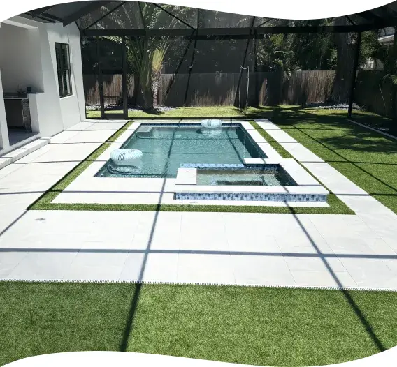Aerial angle of the rectangular pool and raised spa with turf decking.