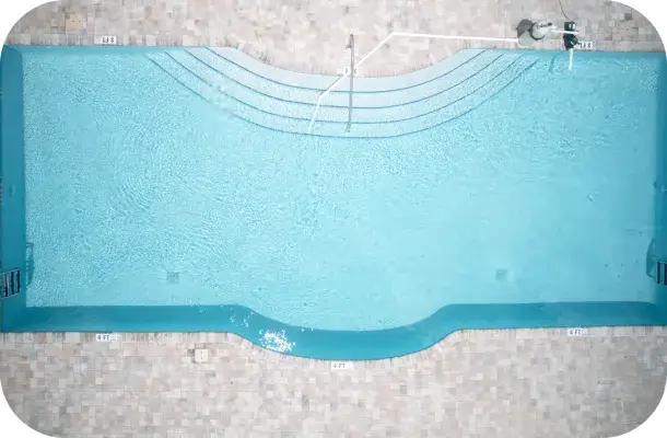 Aerial straight-down view of a wide lap-style pool with built-in bench seating along one wall.