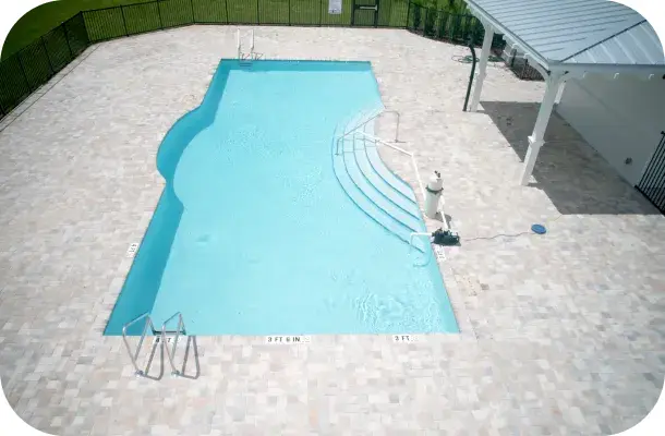 Aerial view of the pool's zero-entry curved edge and surrounding decking.