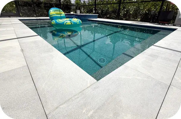 Pool with a float toy and raised spa inside the screened enclosure.