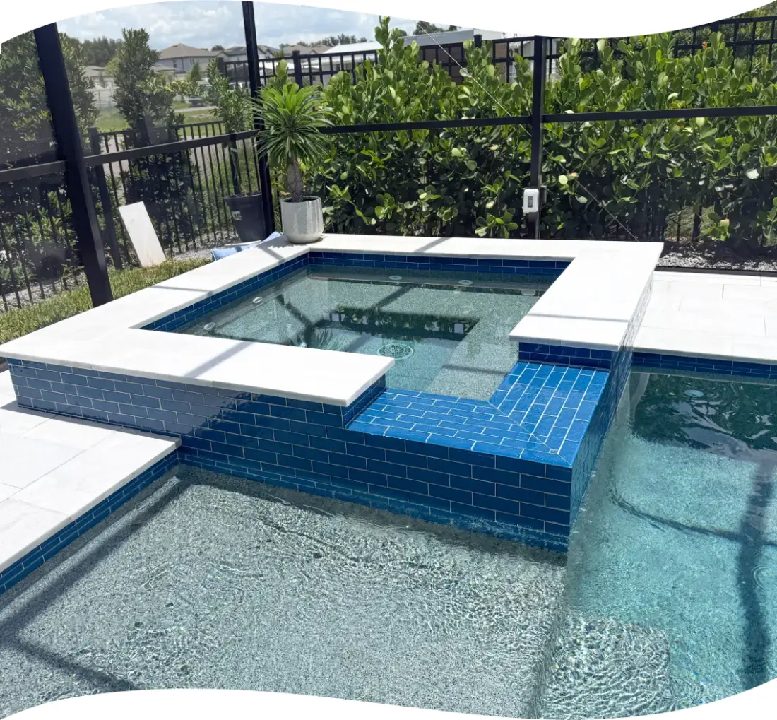 Elevated view of the screened pool and blue-tiled raised spa in the backyard.