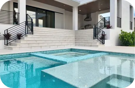 Close view of the pool's raised spa with the home's second story reflected in the water, near the canal.