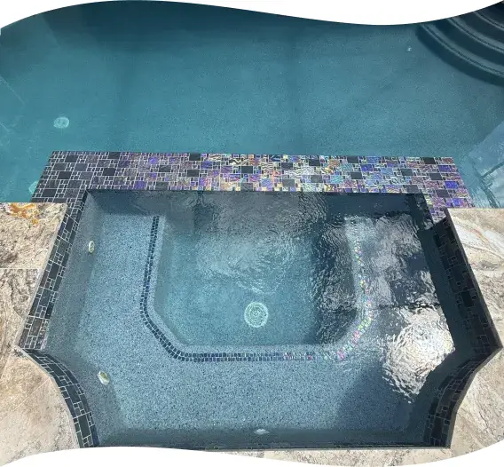 Close-up of the corner raised spa with bubbling water jets and travertine coping.