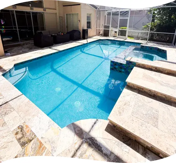 Geometric pool with an angled bench seat and travertine decking inside a screened lanai.