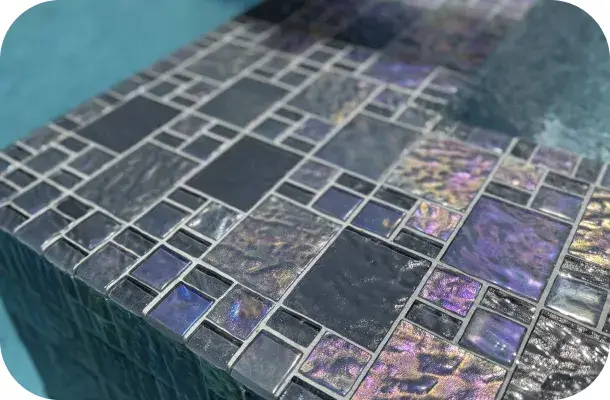 Close-up of the pool's iridescent glass tile finish.