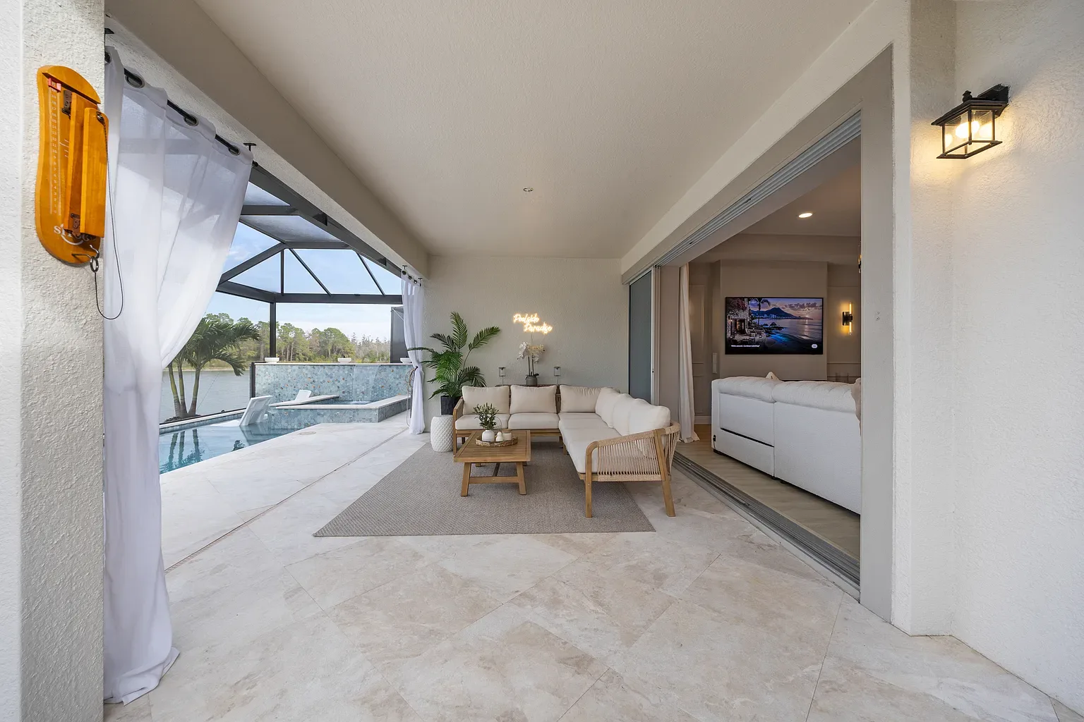 Covered lanai opening through sliding glass doors into the living room of a home in Wesley Chapel, Florida.