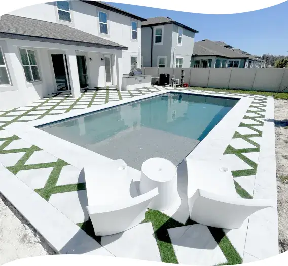 Rectangular pool with a built-in bench seat and curved lounge chairs beside freshly sodded lawn.