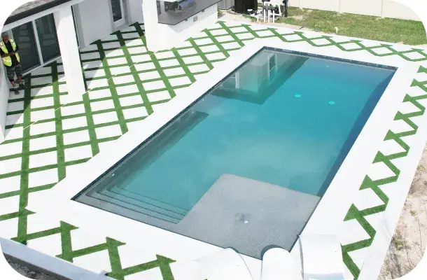 Aerial view of the finished pool with a built-in bench seat and diamond-pattern sod.